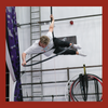 Aerial hoop student performs a move on the top of the equipment