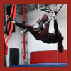 trapeze student pulls herself up to stand on the bar