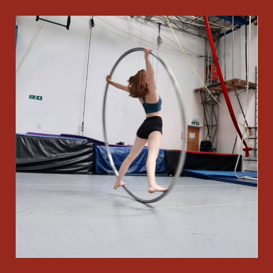 cyr wheel student performs a spin in the wheel