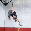 Female straps student holds a meathook position on the aerial straps