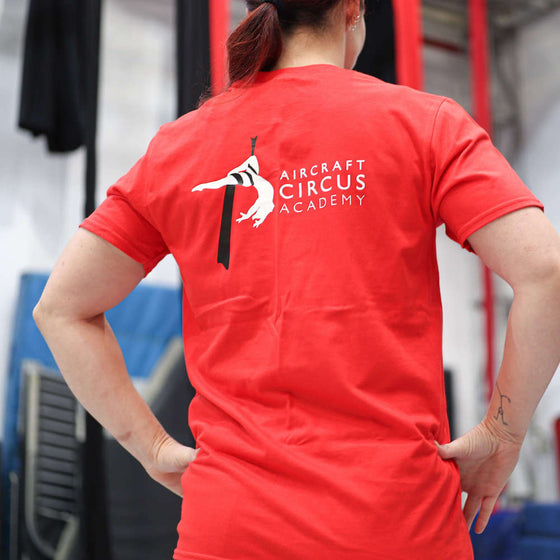 Circus student faces away from the camera to show the back of her AirCraft Circus Academy tshirt