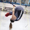 Trapeze student holding a pike position under the bar