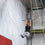 Circus artist holds onto flying trapeze bar mid swing