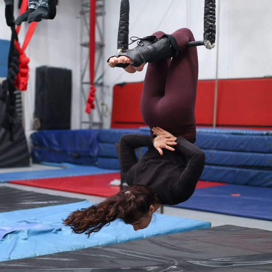 Trapeze student in a knee hang