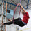 Aerial hoop student sits in the hoop smiling at the camera